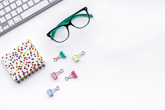 Office desk in order. Geometry. Computer keyboard and office supplies, glasses on white background top view space for text