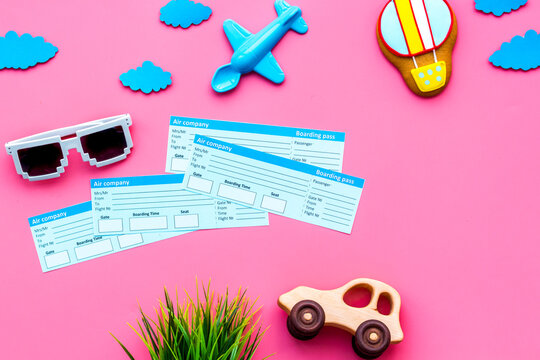 Sample of airplane ticket. Family trip with kid. Airplan, car and air balloon toys. Pink background flat lay space for text