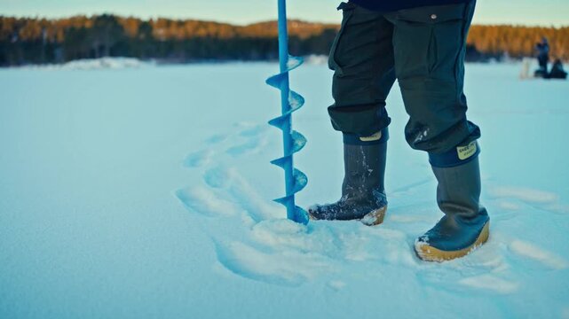 Close-up View Of An Ice Auger On A Frozen Surface During Winter Ice Fishing.