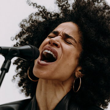 Soulful Female Singer Performing with Passion Under Stage Lights, Exuding Vibrant Energy and Captivating Audiences