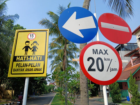 Traffic signs at road intersection in a residential area.