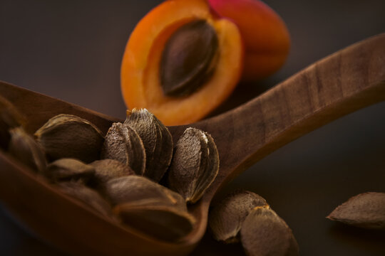 Wooden ladle with apricot kernels closeup