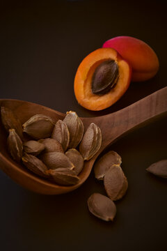 Wooden ladle with apricot seeds closeup