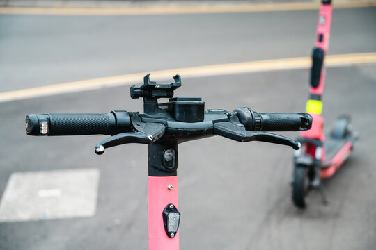 Corby, Northamptonshire, United Kingdom - July 15, 2026: Electric rental scooters parked on urban street for shared micromobility transport