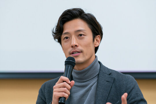 セミナーでマイクを持って講演する男性