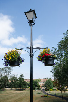 Corby, Northamptonshire, United Kingdom - July 15, 2026: Colorful hanging flower baskets decorating a public park in summer