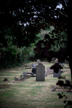 Corby, Northamptonshire, United Kingdom - July 15, 2026: Gravestones in peaceful cemetery framed by trees in summer