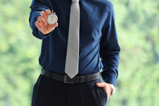 Businessman holding a stopwatch, time management and deadline concept, productivity and efficiency in business