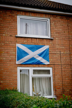 Corby, Northamptonshire, United Kingdom - July 15, 2026: Scottish flag displayed on brick house exterior in residential neighborhood