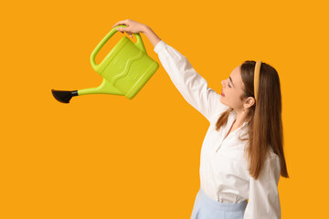 Beautiful young woman with watering can on yellow background © Pixel-Shot