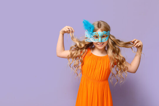 Adorable little girl wearing carnival mask on lilac background