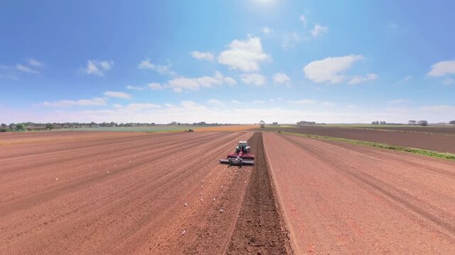 Red soil churns beneath a plow's steady tread. Farming in Lincolnshire
