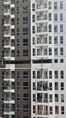 Full frame symmetric view of high-rise residential apartment windows in Jakarta City © Said