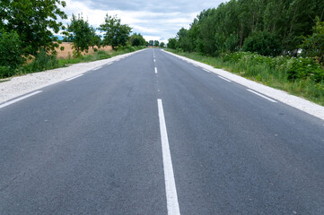 Fototapeta premium New Empty Asphalt Highway Through Rural Countryside Under Clear Blue Sky