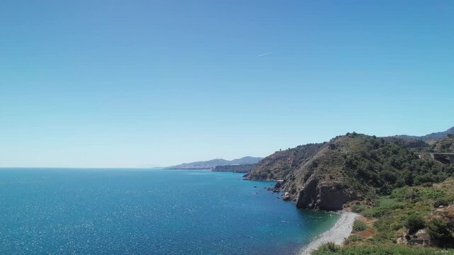 Aerial view of Nerja coastline, Spain, moving backwards