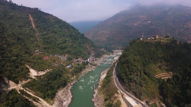 Cinematic aerial view of the scenic Trishuli River valley and highway in Nepal