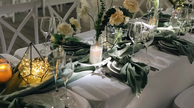 There are glasses and plates with various decorations on the festive table. Shooting in motion