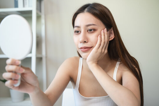 lack of sleep problem,  Worried Asian young woman pointing finger at dark circles under her eyes