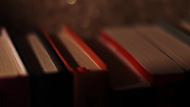 Moody bookshelf close-up with soft backlight and shallow depth of field