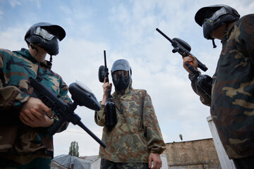 Fototapeta premium Group of several soldiers hold their weapons while on a training field
