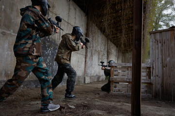 Fototapeta premium Two soldiers point their weapons at a third soldier, ready to fire
