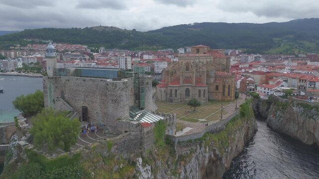 Aerial drone flying over castro urdiales revealing medieval castle and church