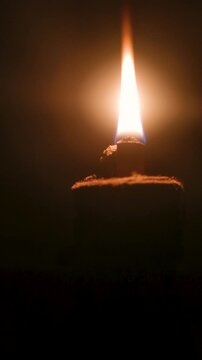 Glowing oil lamp flame burning in absolute darkness 4K
