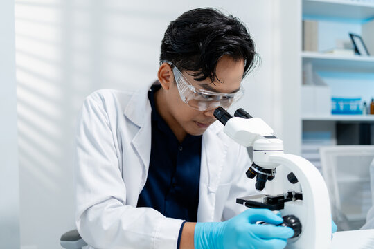 Scientists perform laboratory research using microscopes, test tubes, and modern scientific equipment to analyze samples, representing biotechnology, healthcare, diagnostics, and medical innovation.