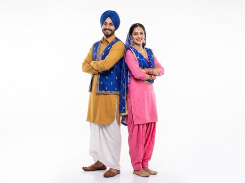Smiling Punjabi Couple in Traditional Attire Standing Back to Back on White Background