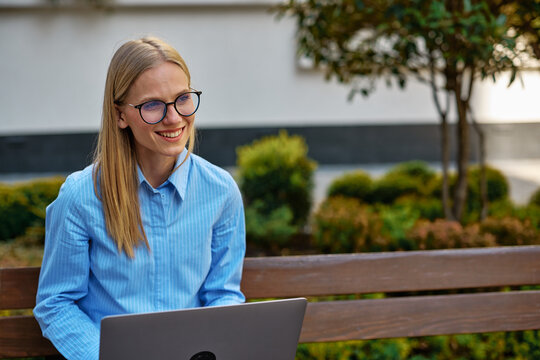 Young woman smiling working remotely outdoors
