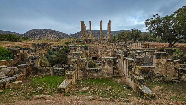 Ruins of ancient Greek city Ptolemais in Eastern Libya with standing pillars and collapsed structures