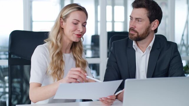 Two Caucasian business partners happy discuss contract terms at office table smiling man with woman working discussing documents insurance investing agreement businessman smile work with businesswoman
