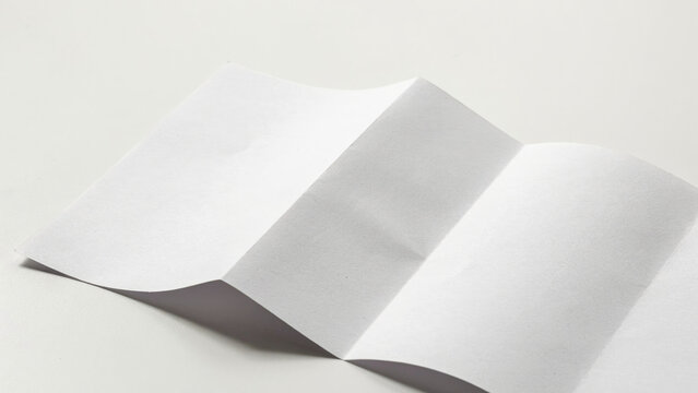 Folded Paper Mockup On White Surface A Close up Photograph blank fold texture material document