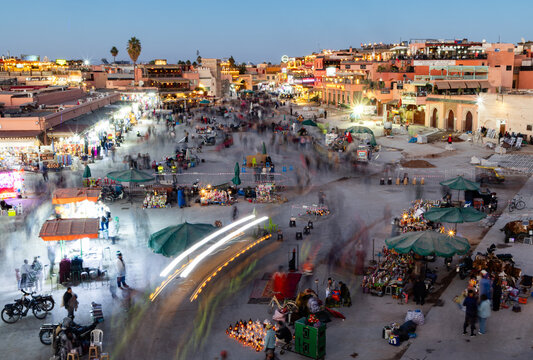 Exploring the lively activity and vibrant atmosphere of Jamaa El Fna market square in Marrakesh during the evening hours in Morocco