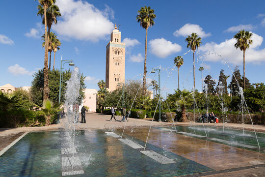 Koutoubia Mosque minaret rises above the park with palm trees in Marrakesh Morocco