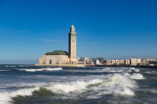 Mosque Hassan Second stands beside the sea in Casablanca, showcasing its large structure against the blue sky and ocean waves