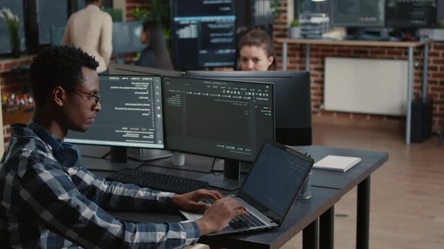 Software developer develops interface concepts around programming data, using office collaboration to refine cloud software workflow and UI logic, inside a software testing office.