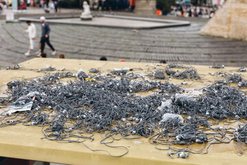 Obraz premium Discarded single use earphones cover the roof of a bus shelter beside a busy street. Plastic waste left by mass tourism raising ecology and sustainability concerns in the city