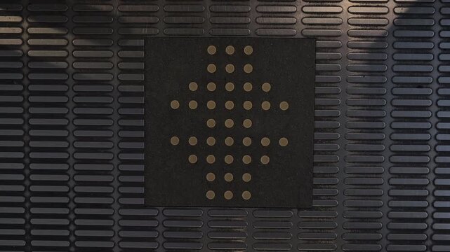 Flashing red downward arrow indicator on elevator floor display panel. Close up footage of illuminated directional LED sign showing descending direction inside modern elevator