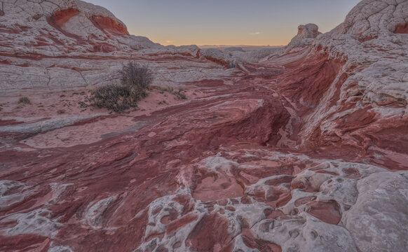 Colorful sandstone formations and unique rock shapes create a striking landscape at White Pocket in Arizona during evening light
