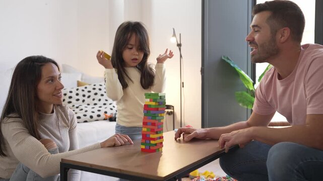 Happy family playing a colorful tower block game