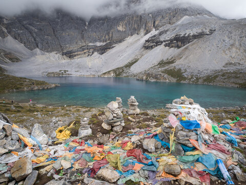 Colorful prayer flags and mani stones at Five-Color Lake in Yading National Park in Sichuan, China