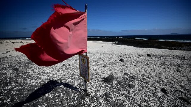 Red Warning Flag Blowing at Popcorn Beach, Dangerous Swimming Conditions and Strong Currents, Corralejo, Fuerteventura, Canary Islands