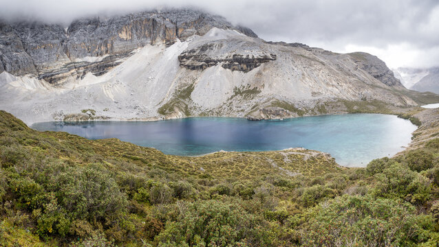 Exploring Five-Color Lake in Yading National Park offers views of glacial waters under grey cliffs in Sichuan, China
