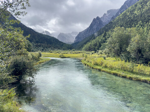 Wide view of Pearl Lake in Yading Nature Reserve offers a glimpse of green water and mountain landscape in Sichuan, China