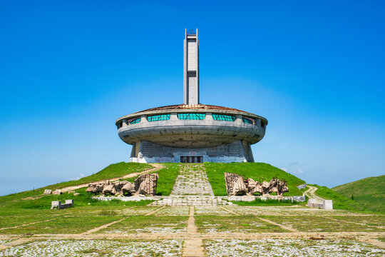 Buzludzha Monument stands tall on a hill in Bulgaria under a clear blue sky