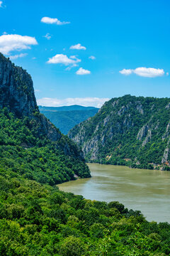 Danube river flows through Iron Gates gorge on a sunny day between Serbia and Romania