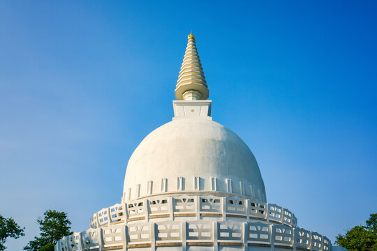 White Peace Stupa dome with golden spire under blue sky in Zalaszanto Hungary