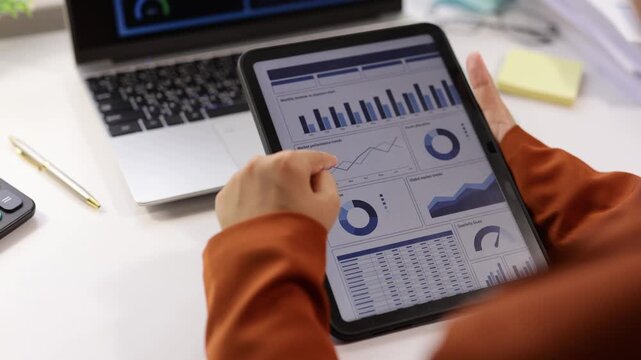 Businesswoman analyzing financial data chart on a digital tablet in the office