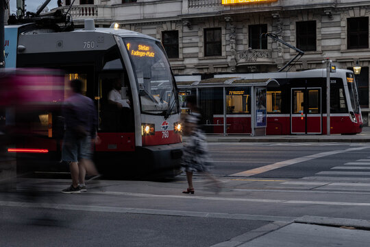 Wien, &Ouml;sterreich: Wiener Linien Stra&szlig;enbahn an einer Haltestelle - Person l&auml;uft zum Zug